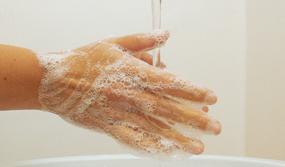 Person wäscht sich die Hände unter fließendem Wasser