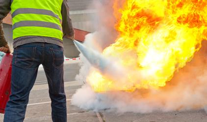 Mann mit Feuerlöscher löscht Brand