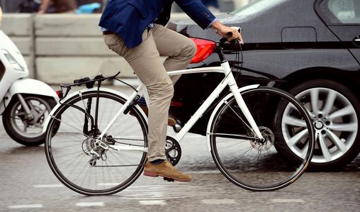 Mann auf Fahrrad auf einer dicht befahrenen Straße