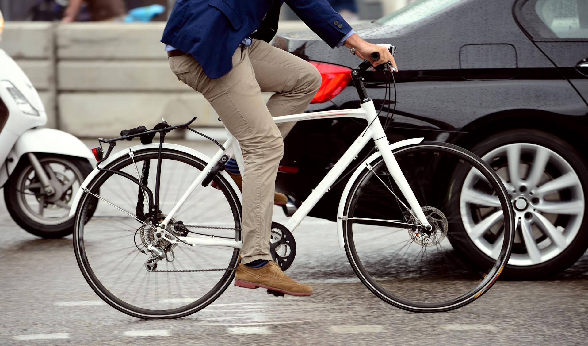 Mann auf Fahrrad auf einer dicht befahrenen Straße